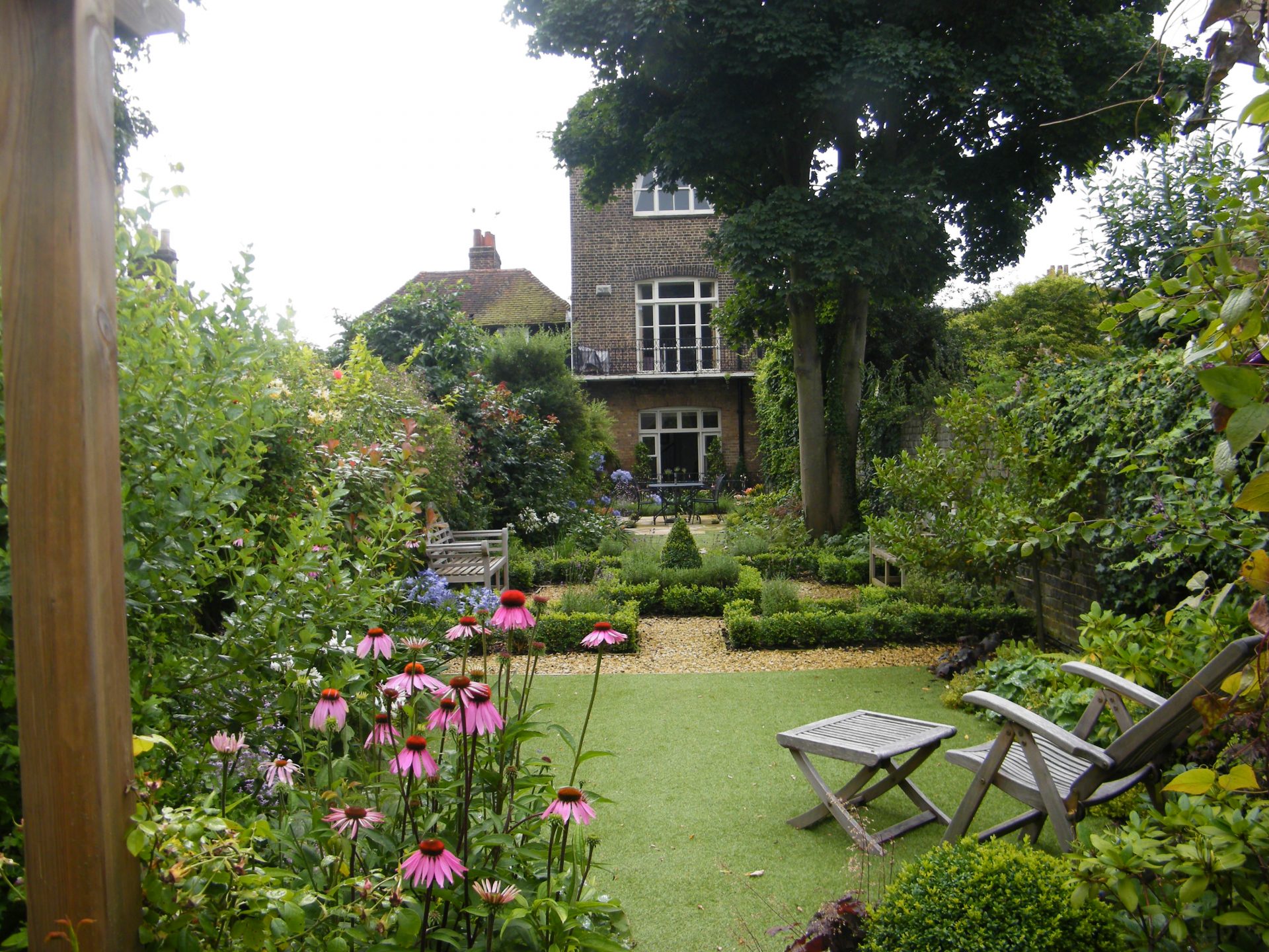 A traditional herbaceous planting border with layered perennials and roses in a South East England garden