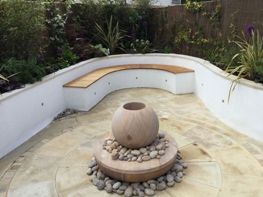 Natural water feature in a garden design project in Caterham, Surrey, surrounded by marginal planting