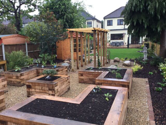 Garden construction in progress showing drainage and terracing work on a sloped site