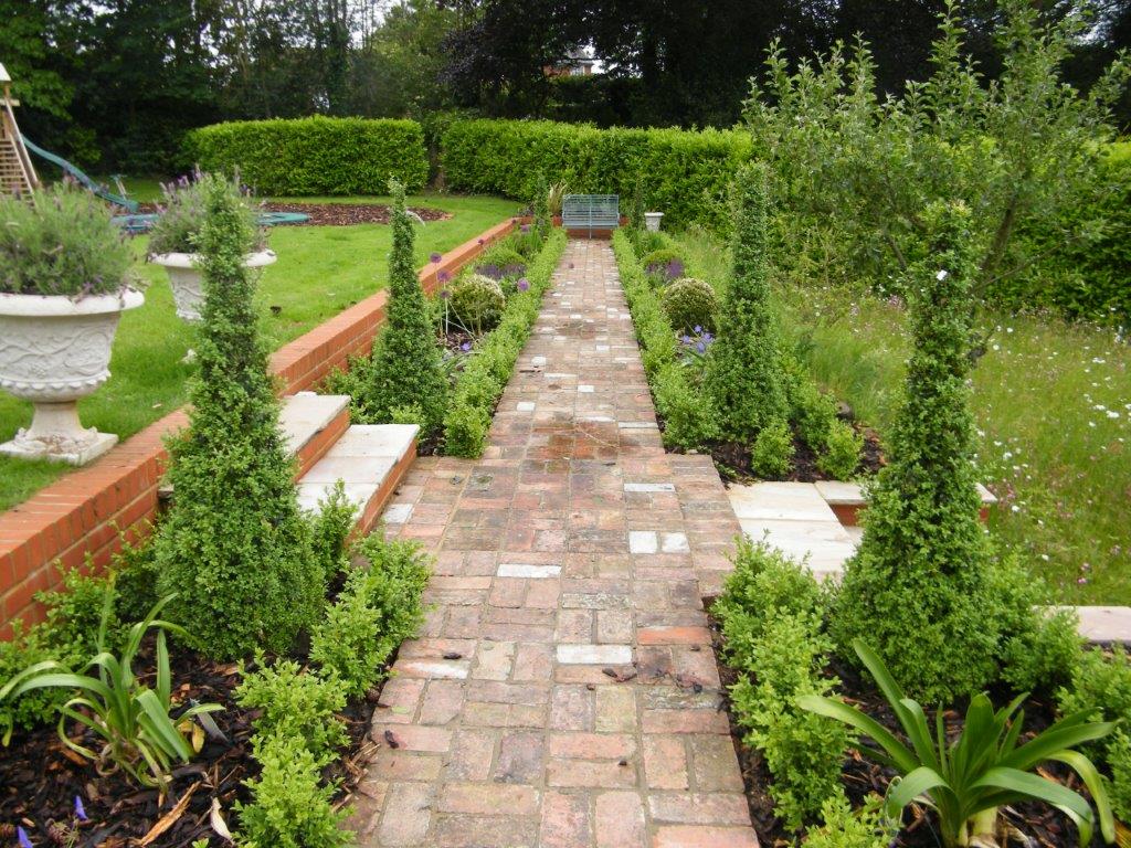 An established garden border in Pembury, Kent, showing mature perennials and grasses with defined edging